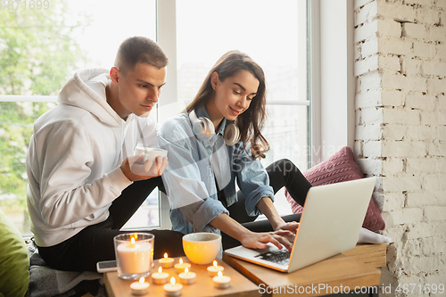 Image of Quarantine lockdown, stay home concept - young beautiful caucasian couple enjoying new lifestyle during coronavirus worldwide health emergency