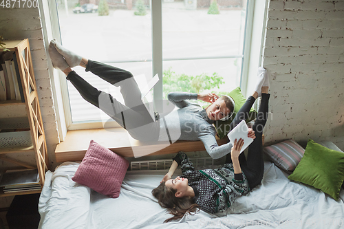 Image of Quarantine lockdown, stay home concept - young beautiful caucasian couple enjoying new lifestyle during coronavirus worldwide health emergency