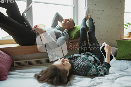 Image of Quarantine lockdown, stay home concept - young beautiful caucasian couple enjoying new lifestyle during coronavirus worldwide health emergency