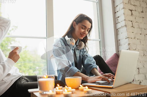 Image of Quarantine lockdown, stay home concept - young beautiful caucasian couple enjoying new lifestyle during coronavirus worldwide health emergency