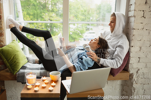 Image of Quarantine lockdown, stay home concept - young beautiful caucasian couple enjoying new lifestyle during coronavirus worldwide health emergency