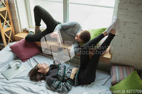 Image of Quarantine lockdown, stay home concept - young beautiful caucasian couple enjoying new lifestyle during coronavirus worldwide health emergency