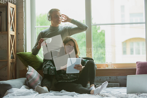 Image of Quarantine lockdown, stay home concept - young beautiful caucasian couple enjoying new lifestyle during coronavirus worldwide health emergency