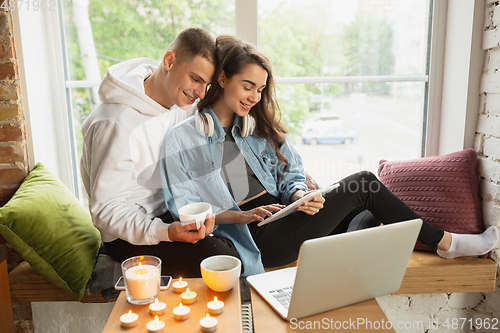 Image of Quarantine lockdown, stay home concept - young beautiful caucasian couple enjoying new lifestyle during coronavirus worldwide health emergency