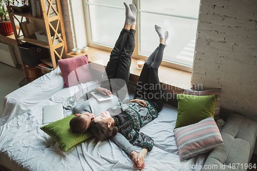 Image of Quarantine lockdown, stay home concept - young beautiful caucasian couple enjoying new lifestyle during coronavirus worldwide health emergency