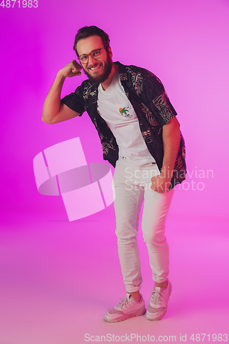 Image of Young caucasian musician, dancer, partyhost in neon light