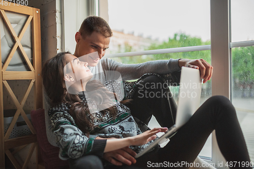 Image of Quarantine lockdown, stay home concept - young beautiful caucasian couple enjoying new lifestyle during coronavirus worldwide health emergency