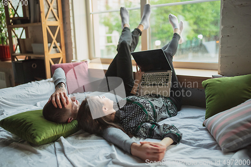 Image of Quarantine lockdown, stay home concept - young beautiful caucasian couple enjoying new lifestyle during coronavirus worldwide health emergency