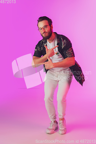 Image of Young caucasian musician, dancer, partyhost in neon light