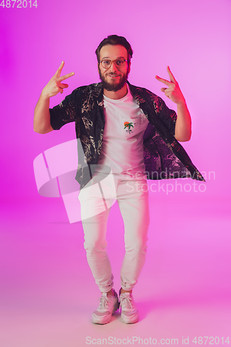 Image of Young caucasian musician, dancer, partyhost in neon light