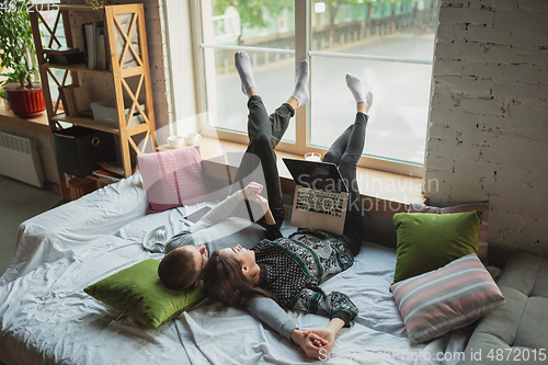 Image of Quarantine lockdown, stay home concept - young beautiful caucasian couple enjoying new lifestyle during coronavirus worldwide health emergency