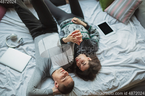 Image of Quarantine lockdown, stay home concept - young beautiful caucasian couple enjoying new lifestyle during coronavirus worldwide health emergency