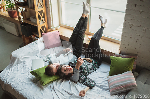 Image of Quarantine lockdown, stay home concept - young beautiful caucasian couple enjoying new lifestyle during coronavirus worldwide health emergency