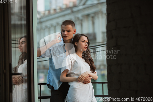 Image of Quarantine lockdown, stay home concept - young beautiful caucasian couple enjoying new lifestyle during coronavirus worldwide health emergency