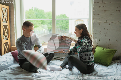 Image of Quarantine lockdown, stay home concept - young beautiful caucasian couple enjoying new lifestyle during coronavirus worldwide health emergency