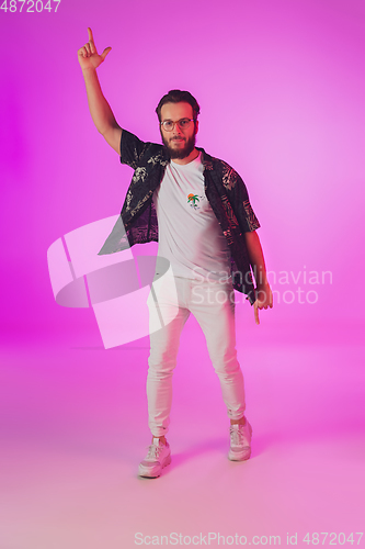 Image of Young caucasian musician, dancer, partyhost in neon light