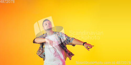 Image of Young caucasian musician, dancer, party host, DJ on gradient background in neon light, flyer with copyspace for ad