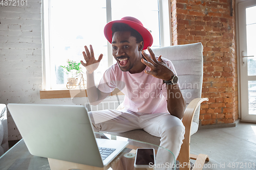 Image of African-american man during videocall with his band sitting at home, musicians during quarantine and insulation