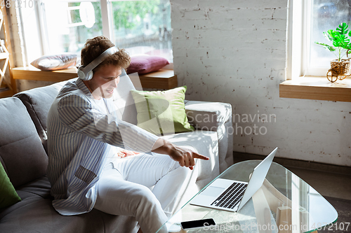 Image of Caucasian man during online concert at home isolated and quarantined, impressive improvising, listening to band playing