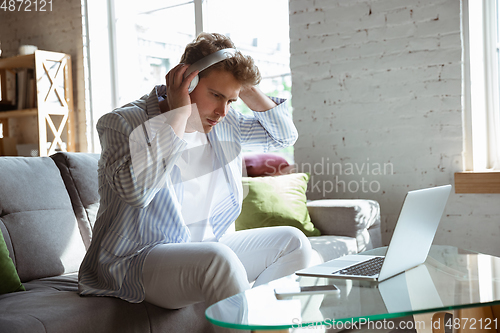 Image of Caucasian man during online concert at home isolated and quarantined, impressive improvising, listening to band playing