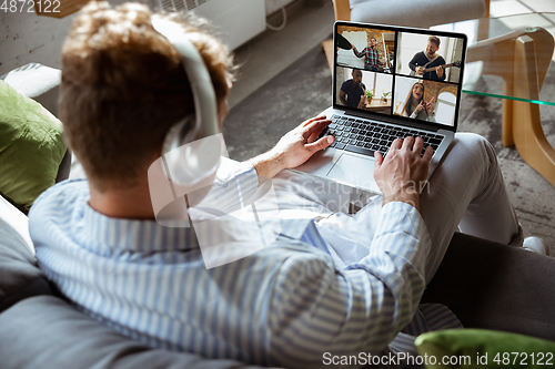 Image of Caucasian man during online concert at home isolated and quarantined, impressive improvising, listening to band playing