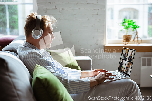 Image of Caucasian man during online concert at home isolated and quarantined, impressive improvising, listening to band playing