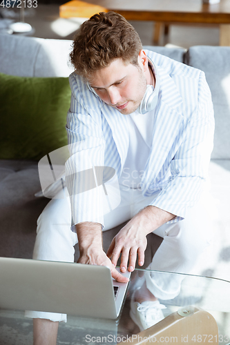Image of Caucasian man during online concert at home isolated and quarantined, impressive improvising, listening to band playing