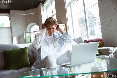 Image of Caucasian man during online concert at home isolated and quarantined, impressive improvising, listening to band playing