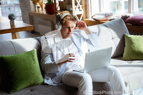 Image of Caucasian man during online concert at home isolated and quarantined, impressive improvising, listening to band playing