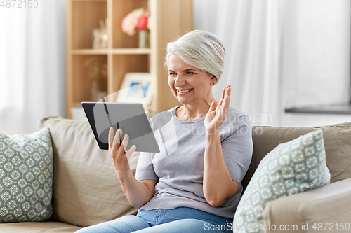 Image of senior woman having video call on tablet pc