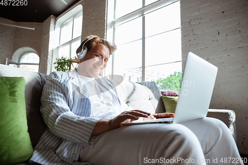 Image of Caucasian man during online concert at home isolated and quarantined, impressive improvising, listening to band playing