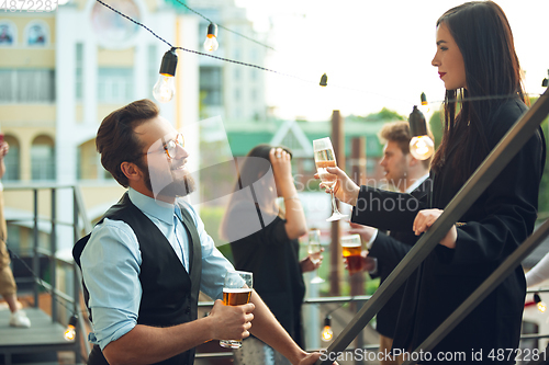 Image of Group of young caucasian people celebrating, look happy, have corporate party at office or bar