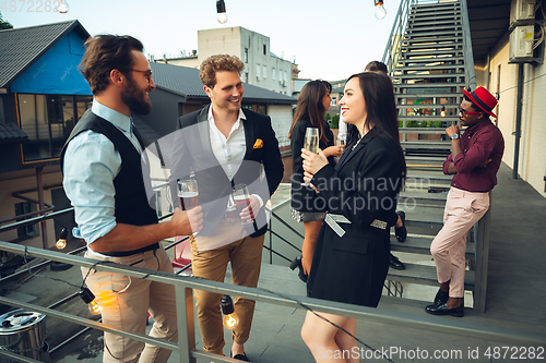 Image of Group of young caucasian people celebrating, look happy, have corporate party at office or bar