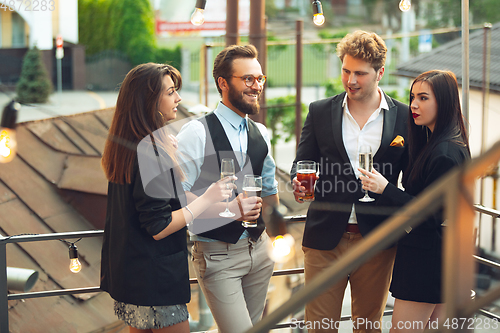 Image of Group of young caucasian people celebrating, look happy, have corporate party at office or bar