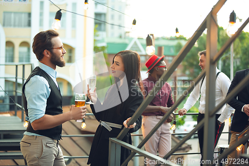 Image of Group of young caucasian people celebrating, look happy, have corporate party at office or bar