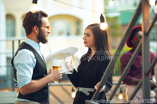 Image of Man and woman celebrating, look happy, have corporate party at office or bar