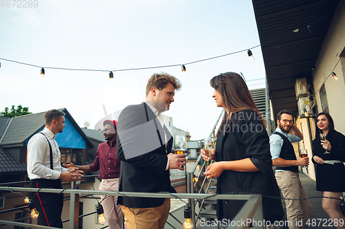 Image of Group of young caucasian people celebrating, look happy, have corporate party at office or bar