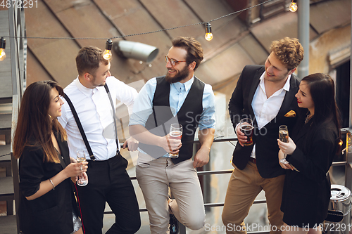 Image of Group of young caucasian people celebrating, look happy, have corporate party at office or bar