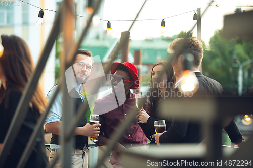 Image of Multiethnic group of people celebrating, look happy, have corporate party at office or bar