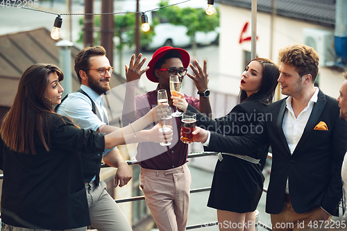 Image of Multiethnic group of people celebrating, look happy, have corporate party at office or bar