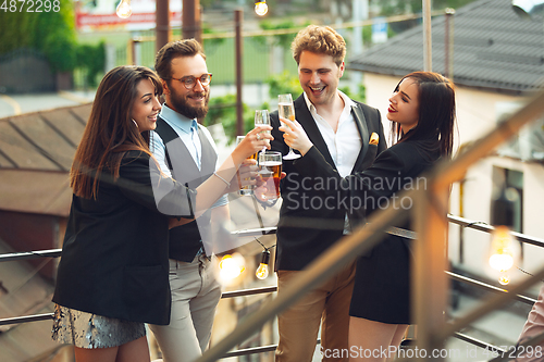 Image of Group of young caucasian people celebrating, look happy, have corporate party at office or bar
