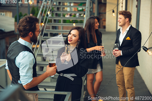 Image of Group of young caucasian people celebrating, look happy, have corporate party at office or bar