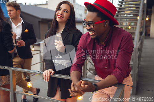 Image of Group of young people celebrating, look happy, have corporate party at office or bar