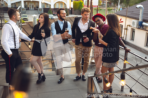 Image of Multiethnic group of people celebrating, look happy, have corporate party at office or bar