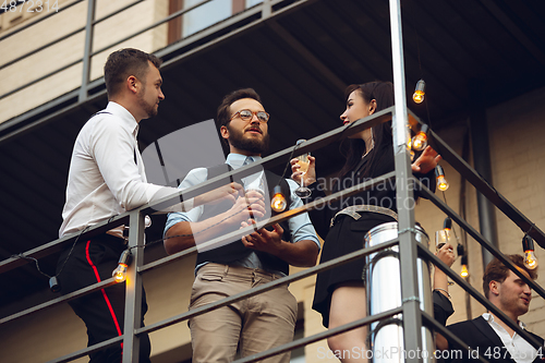Image of Group of young caucasian people celebrating, look happy, have corporate party at office or bar