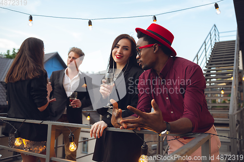 Image of Group of young people celebrating, look happy, have corporate party at office or bar