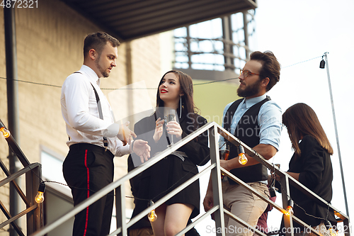 Image of Group of young caucasian people celebrating, look happy, have corporate party at office or bar