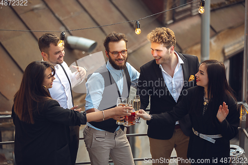 Image of Group of young caucasian people celebrating, look happy, have corporate party at office or bar