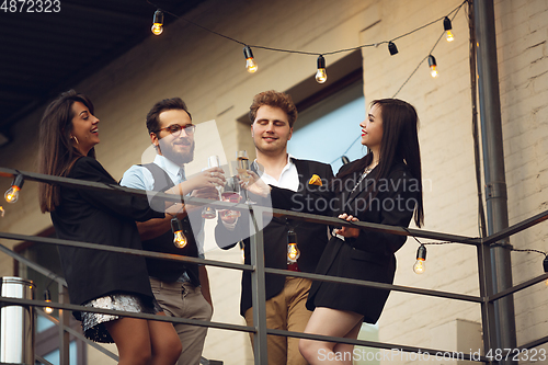 Image of Group of young caucasian people celebrating, look happy, have corporate party at office or bar