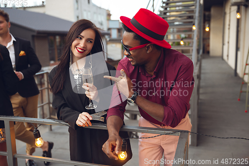 Image of Group of young people celebrating, look happy, have corporate party at office or bar